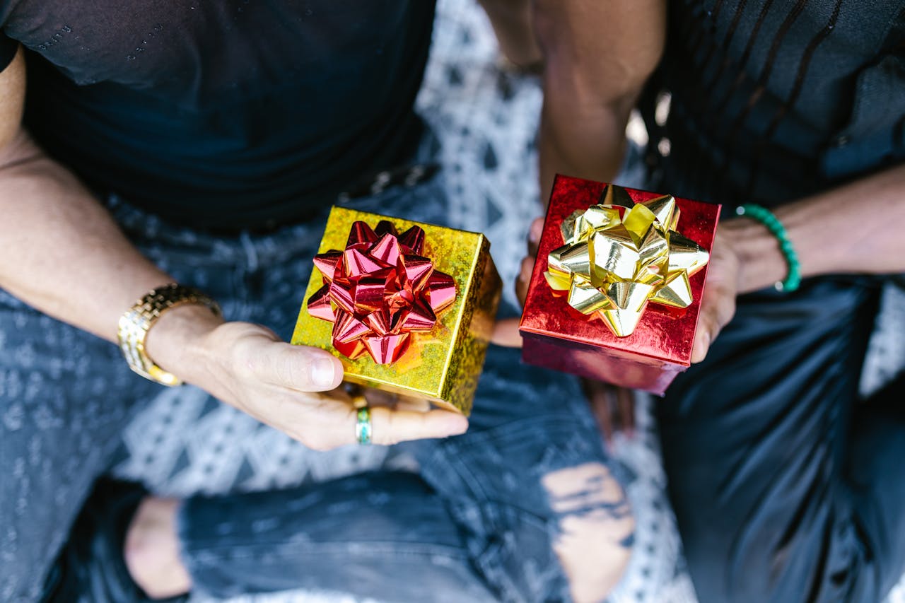 Two people holding beautifully wrapped gift boxes with bows, perfect for celebrations.